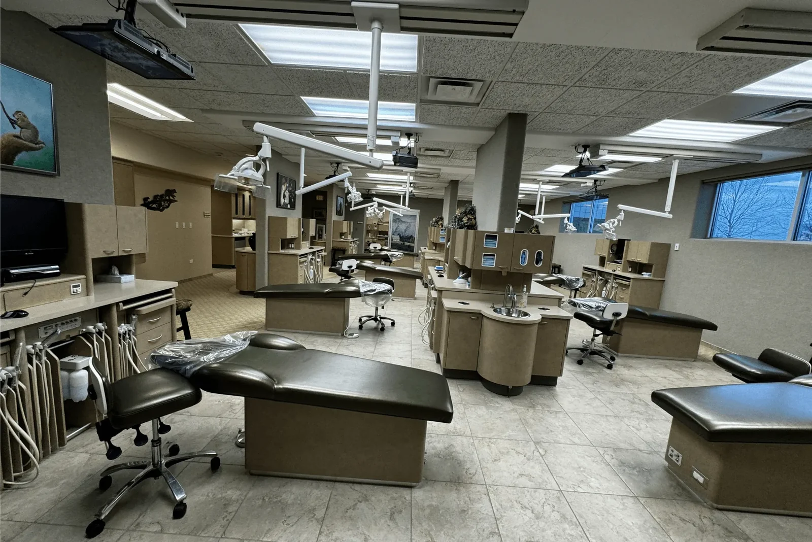 Open pediatric dental treatment bay with chairs and equipment.