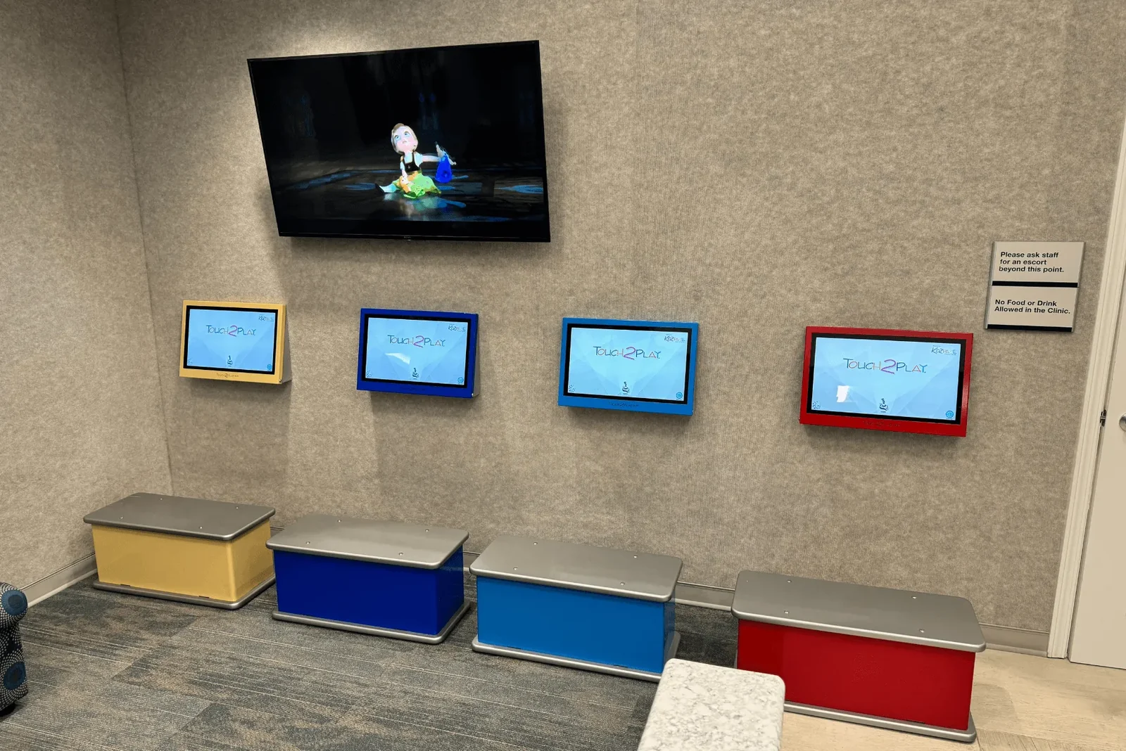 Children's entertainment screens mounted on a wall inside the office.