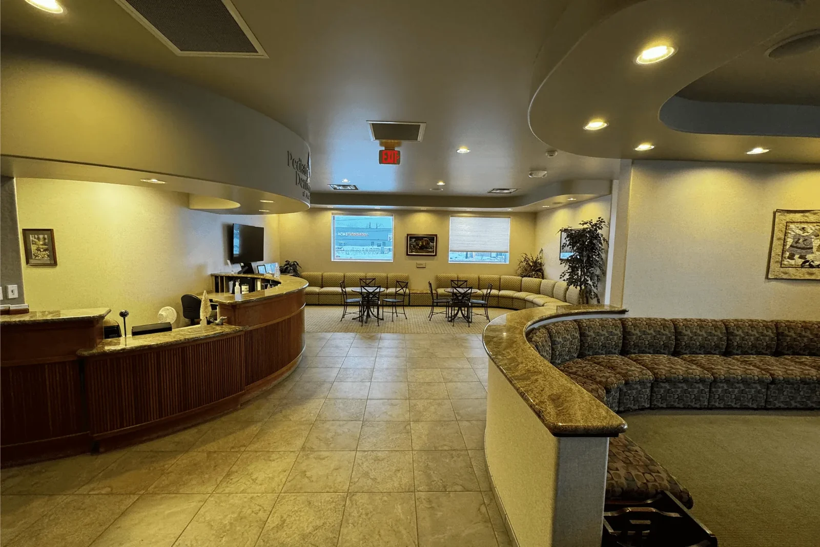 Pediatric Dentistry of Alaska reception area with a curved front desk and seating.
