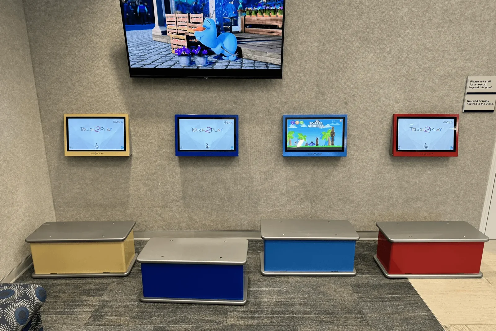 Colorful children's activity stations below a wall-mounted television.