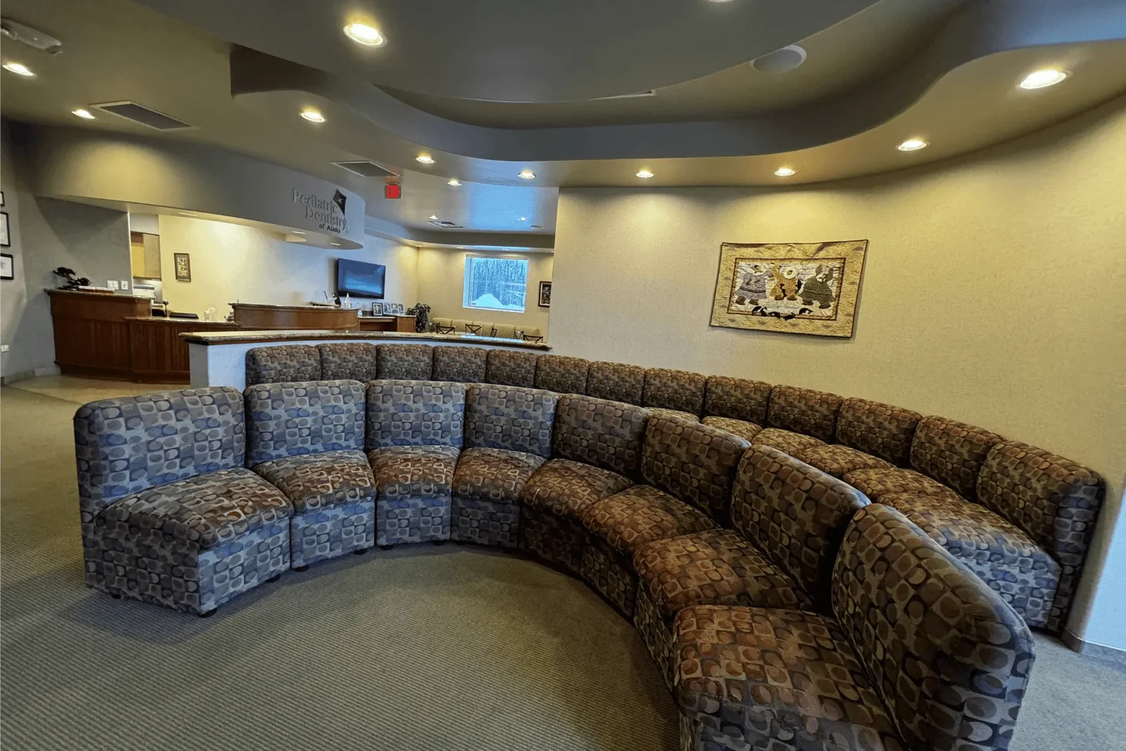 Comfortable waiting area with curved seating inside Pediatric Dentistry of Alaska.