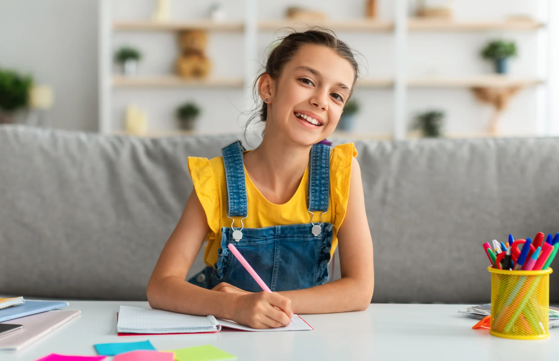 A child writing at home for At-Home Dental Care.
